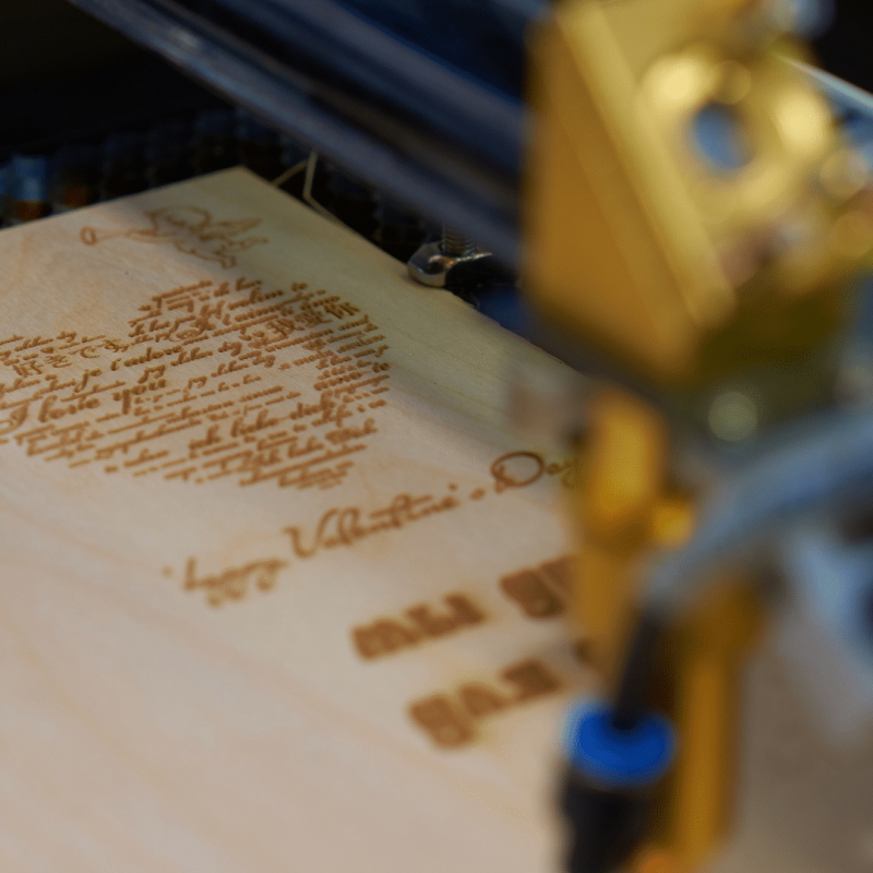 máquina de corte láser personalizando un regalo en madera