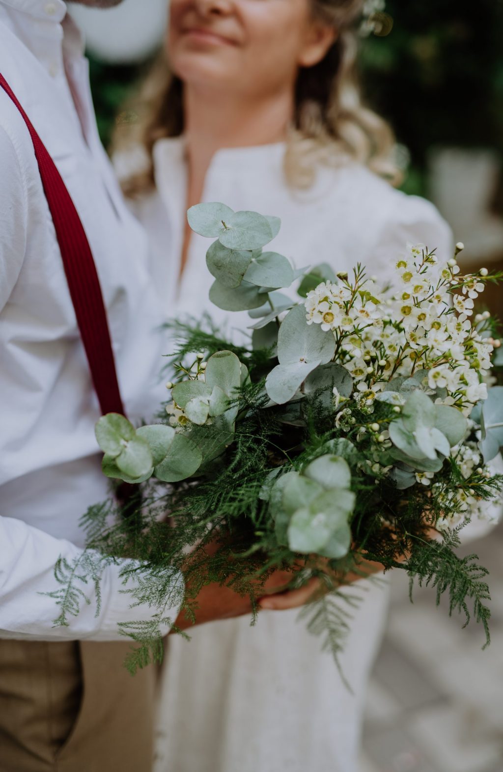 Close-up of a wedding bouquet holding groom and wife.