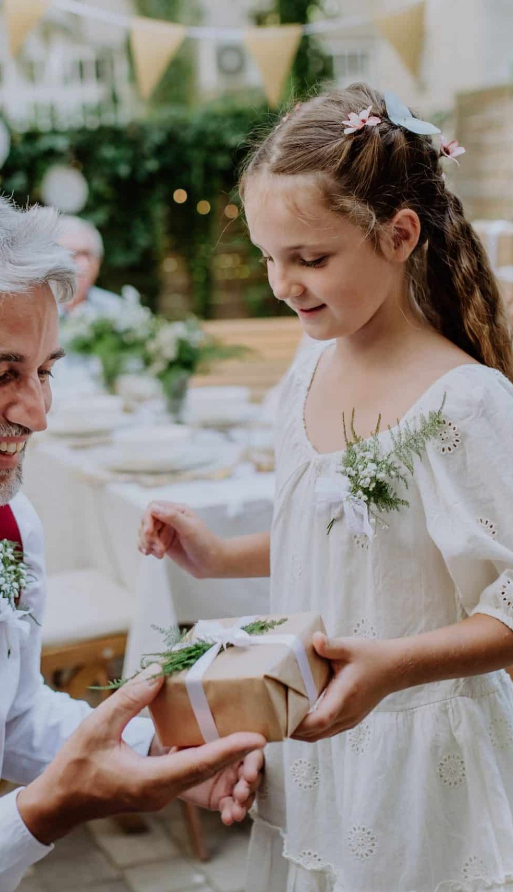 niña entregando regalo personalizado a su padre en una celebración familiar