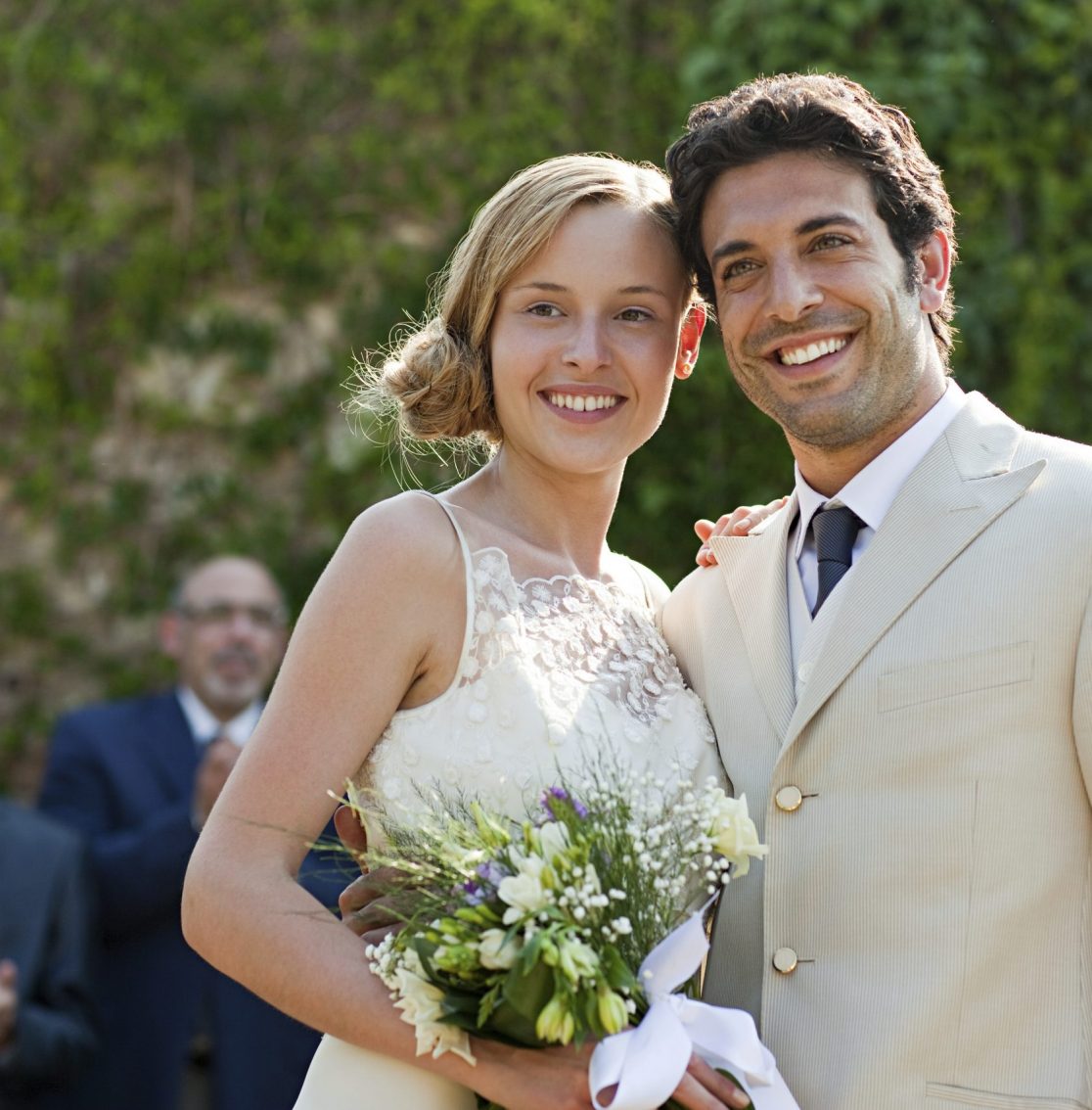 Newlyweds at marriage ceremony, looking away